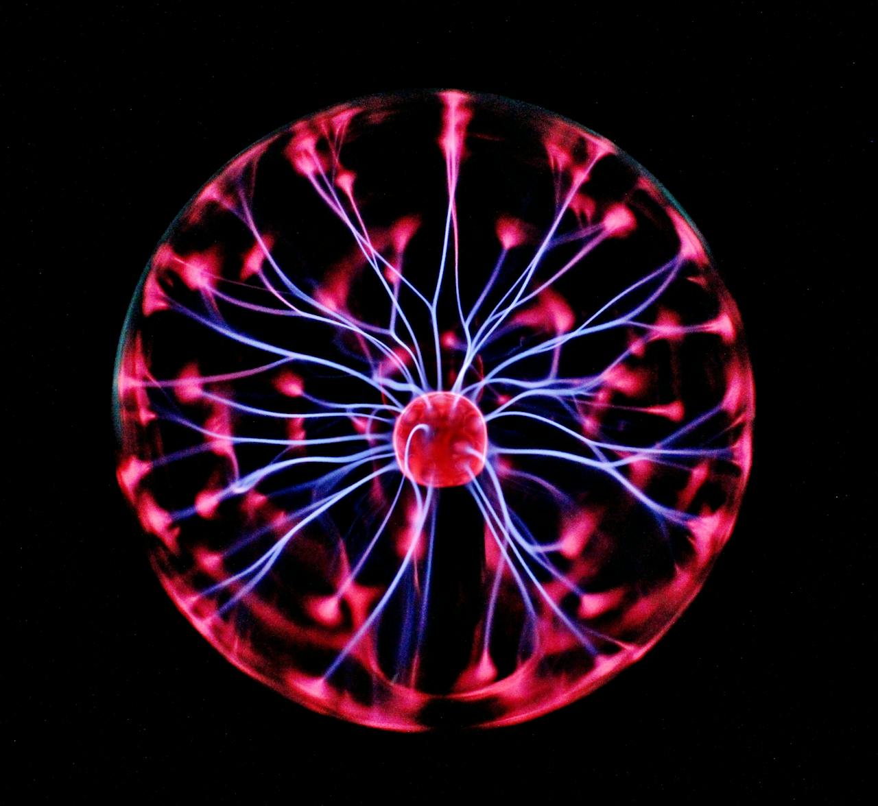 gallery-05 Close-up of a plasma globe with vibrant neon sparks against a dark background.
